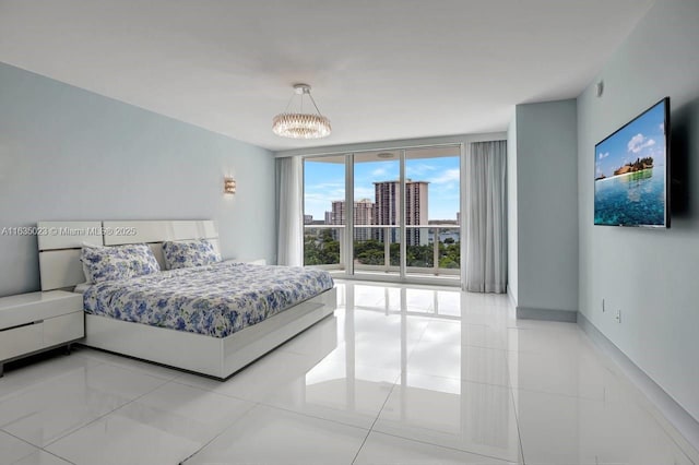 tiled bedroom featuring an inviting chandelier, baseboards, and a wall of windows