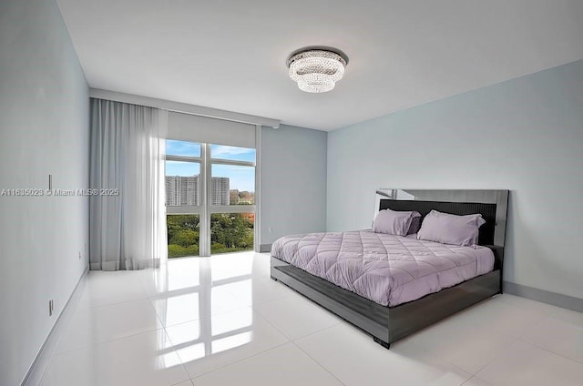 tiled bedroom featuring baseboards, floor to ceiling windows, and a notable chandelier