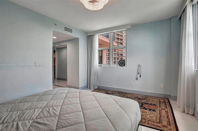 bedroom with baseboards, visible vents, and an inviting chandelier