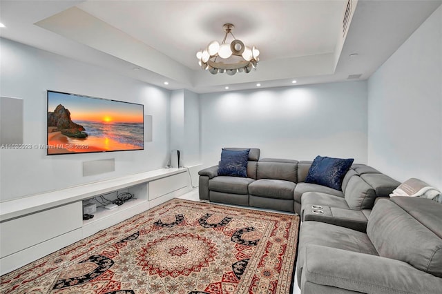 living room with an inviting chandelier and a tray ceiling