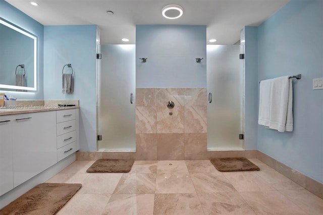 bathroom with a shower stall, baseboards, and vanity