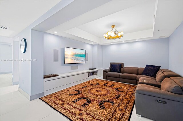 living room with an inviting chandelier, light tile patterned floors, a tray ceiling, and visible vents
