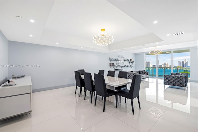 dining space with a tray ceiling, visible vents, an inviting chandelier, and recessed lighting