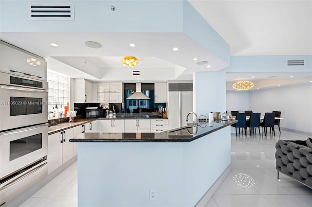 kitchen featuring a sink, double oven, built in refrigerator, light tile patterned floors, and visible vents