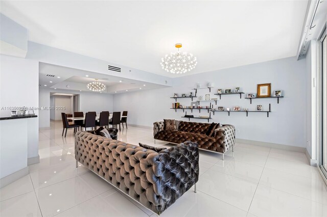 living room with light tile patterned floors, an inviting chandelier, and a tray ceiling