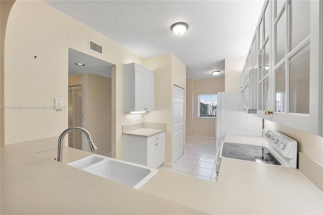 kitchen with white cabinetry, white appliances, sink, a textured ceiling, and light tile patterned floors