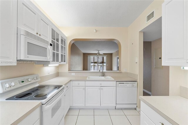 kitchen featuring white appliances, white cabinets, sink, light tile patterned flooring, and ceiling fan