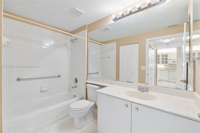 full bathroom featuring vanity, tiled shower / bath, toilet, a textured ceiling, and tile patterned flooring