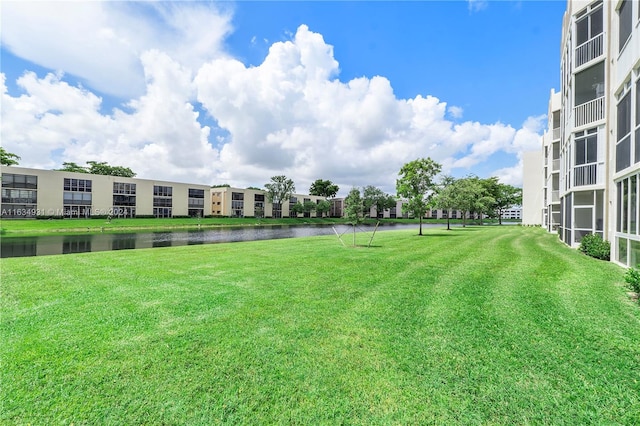 view of community with a yard and a water view