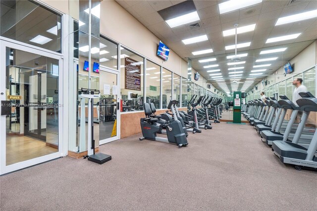 workout area with a drop ceiling and carpet floors