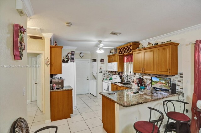 kitchen with ceiling fan, kitchen peninsula, light tile patterned floors, backsplash, and white appliances