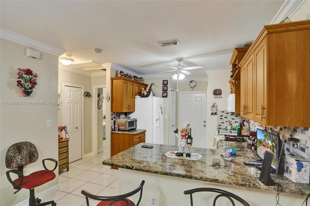 kitchen featuring light tile patterned floors, stone countertops, ceiling fan, backsplash, and kitchen peninsula