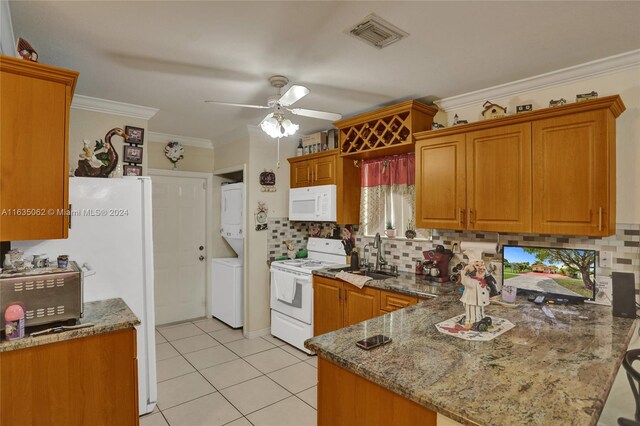 kitchen featuring tasteful backsplash, white appliances, stacked washer and clothes dryer, and ceiling fan