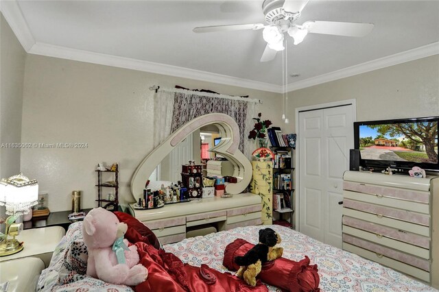 bedroom featuring ceiling fan, crown molding, and a closet