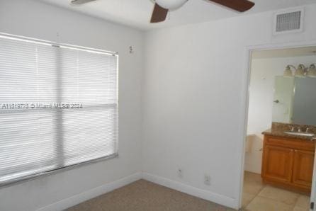 spare room with ceiling fan, sink, and light tile patterned floors