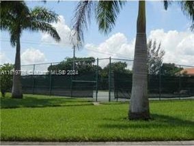 view of sport court featuring a yard