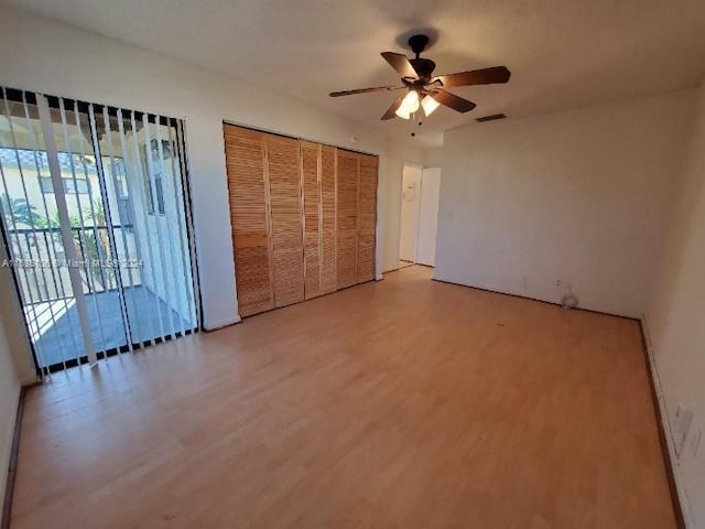 unfurnished bedroom featuring hardwood / wood-style flooring, access to exterior, and ceiling fan