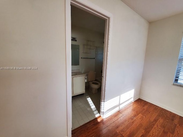 unfurnished bedroom with ensuite bathroom and tile patterned floors