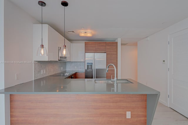 kitchen featuring stainless steel fridge with ice dispenser, kitchen peninsula, backsplash, black electric stovetop, and sink