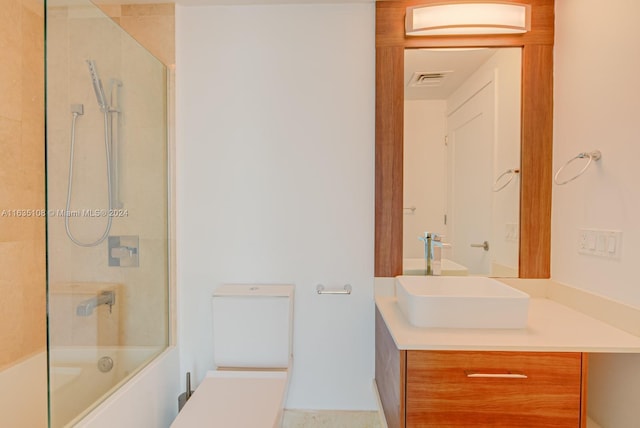 full bathroom featuring vanity, tiled shower / bath combo, and toilet