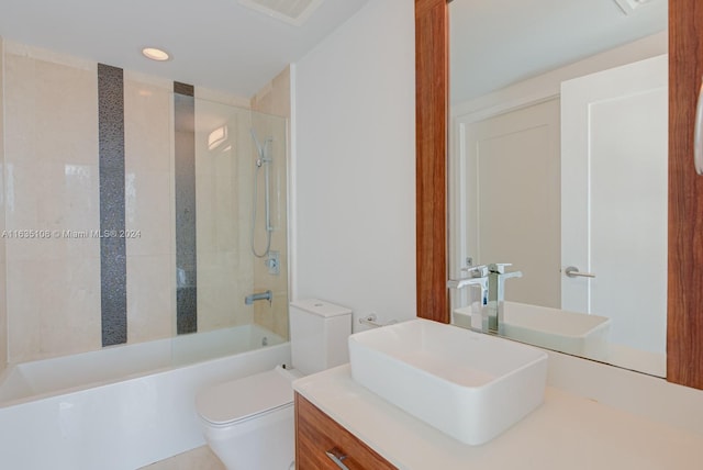 full bathroom featuring vanity, tiled shower / bath combo, and toilet