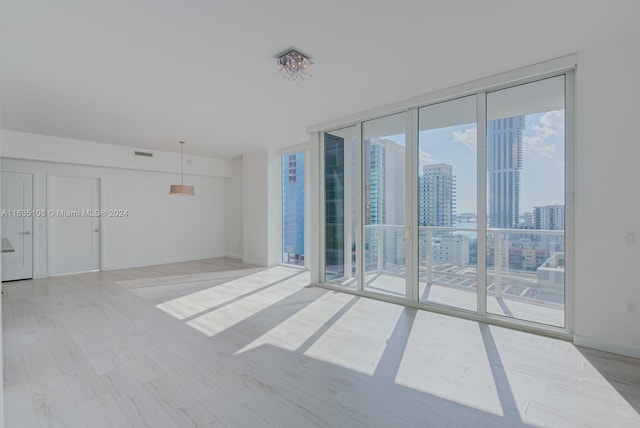 unfurnished room with light wood-type flooring and floor to ceiling windows