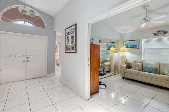 foyer featuring vaulted ceiling, ceiling fan, light tile patterned floors, and baseboards