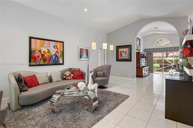 living area with high vaulted ceiling, baseboards, and light tile patterned floors