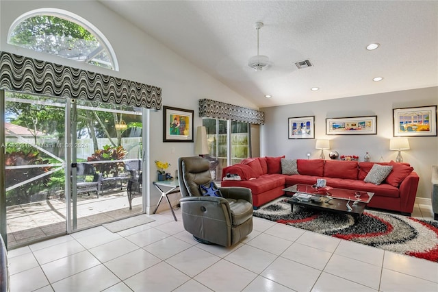 living area with light tile patterned floors, high vaulted ceiling, visible vents, and a healthy amount of sunlight