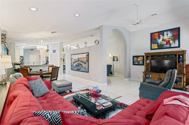 living room featuring arched walkways, light tile patterned floors, lofted ceiling, recessed lighting, and visible vents