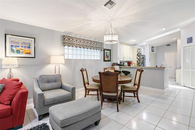 tiled dining room with a chandelier and vaulted ceiling