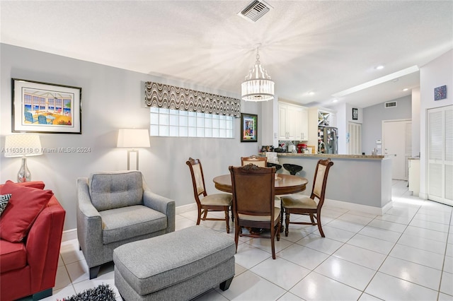 dining space with visible vents, vaulted ceiling, and light tile patterned flooring