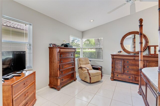 living area with ceiling fan, vaulted ceiling, and light tile patterned floors