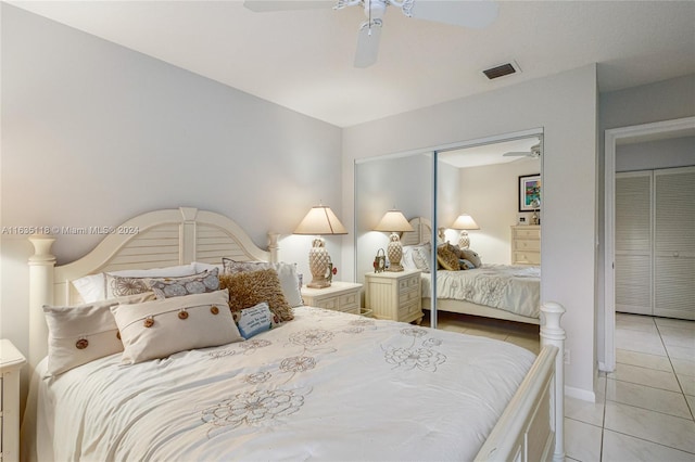 tiled bedroom with ceiling fan and a closet