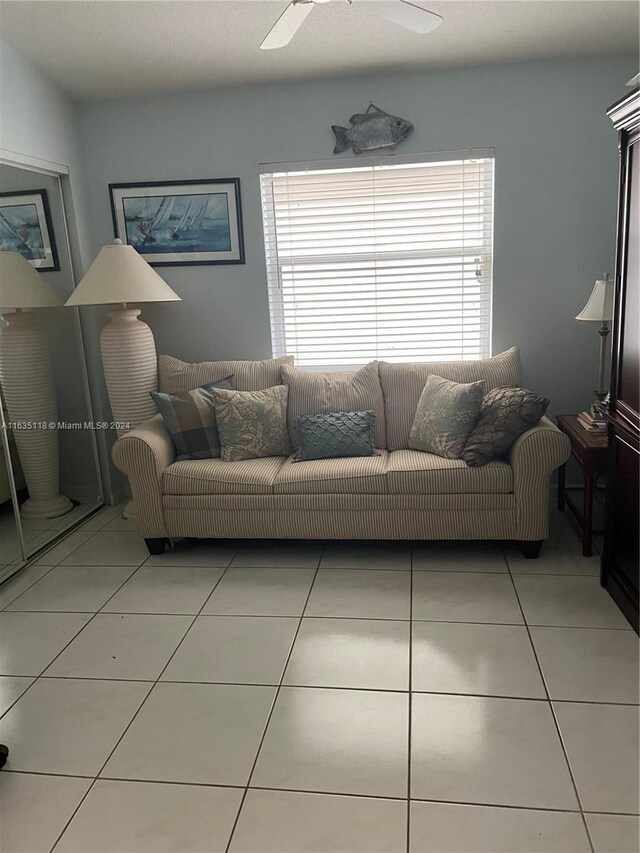 tiled living room featuring ceiling fan