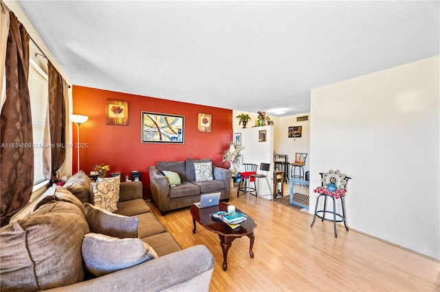 living room featuring light hardwood / wood-style floors and a textured ceiling