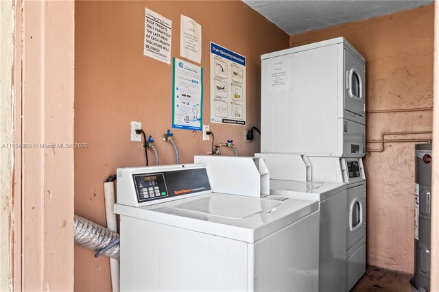 clothes washing area featuring washing machine and clothes dryer, stacked washing maching and dryer, and electric water heater