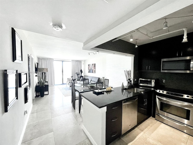 kitchen with sink, light tile patterned flooring, track lighting, and stainless steel appliances