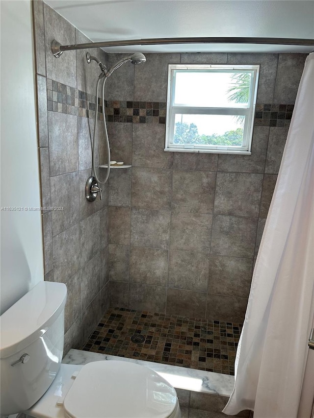 bathroom featuring walk in shower and toilet