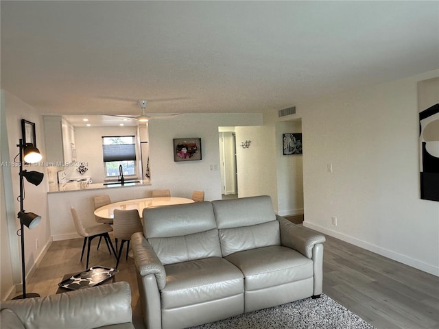 living room with sink, wood-type flooring, and ceiling fan