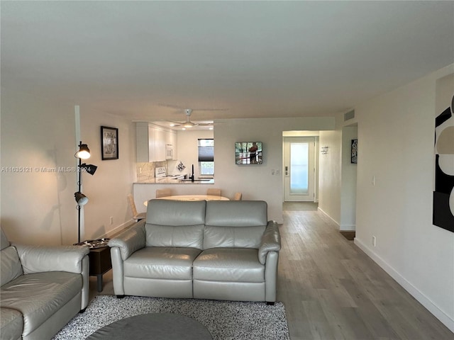 living room with sink, ceiling fan, and hardwood / wood-style floors