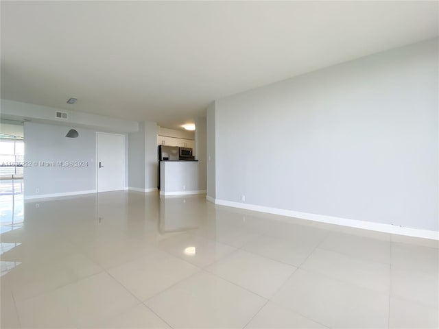 unfurnished room featuring visible vents, baseboards, and light tile patterned flooring