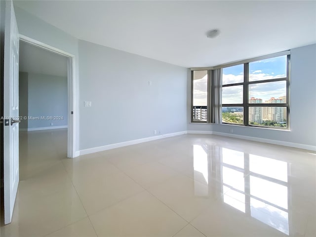 unfurnished room with baseboards and light tile patterned flooring