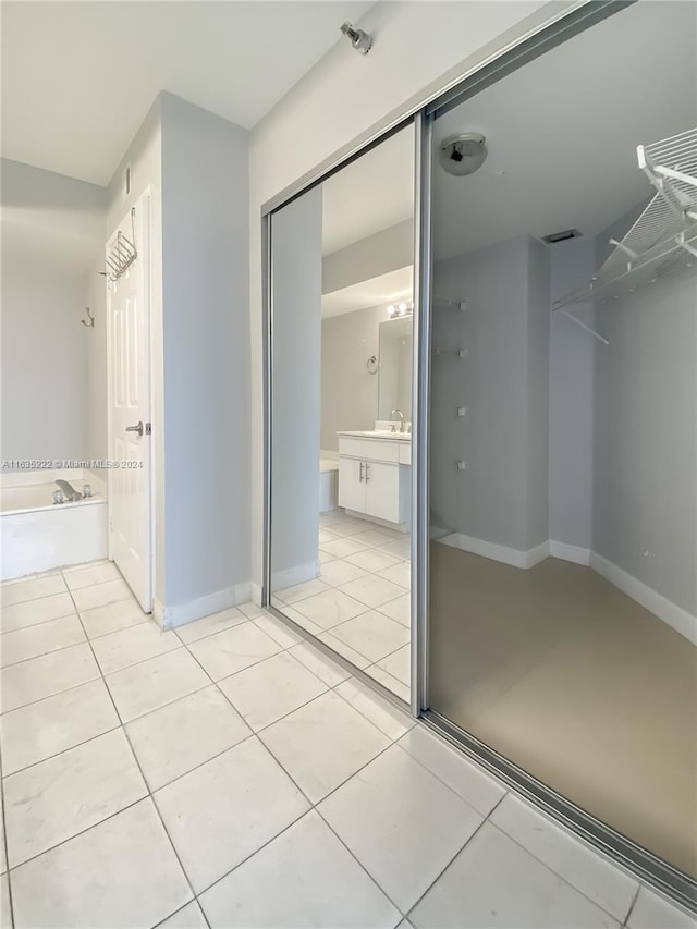 full bathroom with vanity, baseboards, tile patterned flooring, a bath, and visible vents
