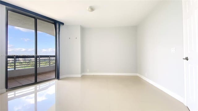 spare room with baseboards and expansive windows