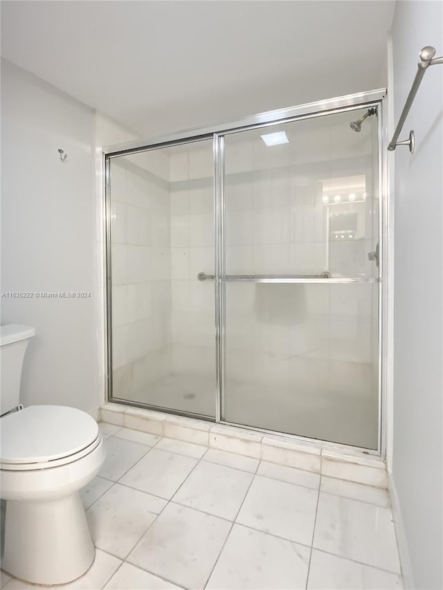 bathroom featuring toilet, tile patterned floors, and walk in shower