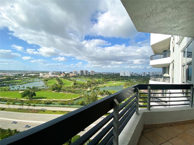 balcony featuring a water view, view of golf course, and a city view