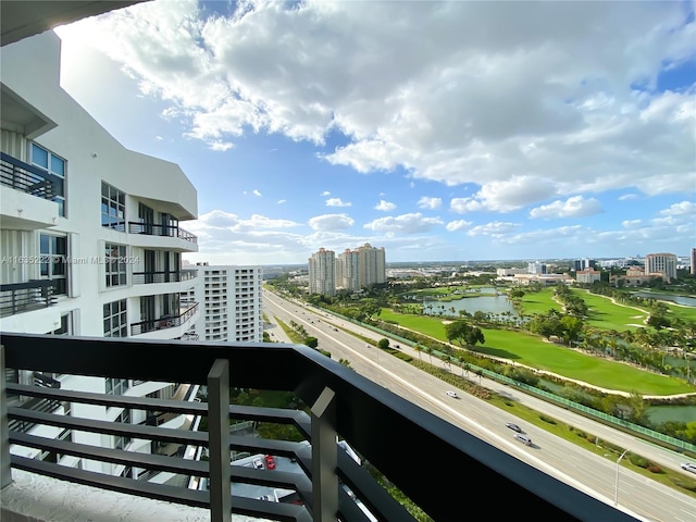 balcony with a water view, a view of city, and golf course view