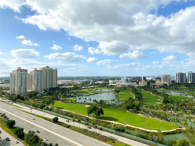bird's eye view with a city view, view of golf course, and a water view