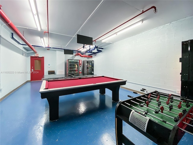 recreation room with billiards and concrete block wall